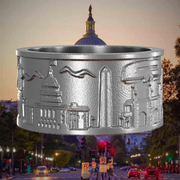 Ring aus Edelstahl mit Reliefs bekannter Sehenswürdigkeiten der Stadt Washington. Den Hintergrund bildet eine Ansicht der Stadt Washington.