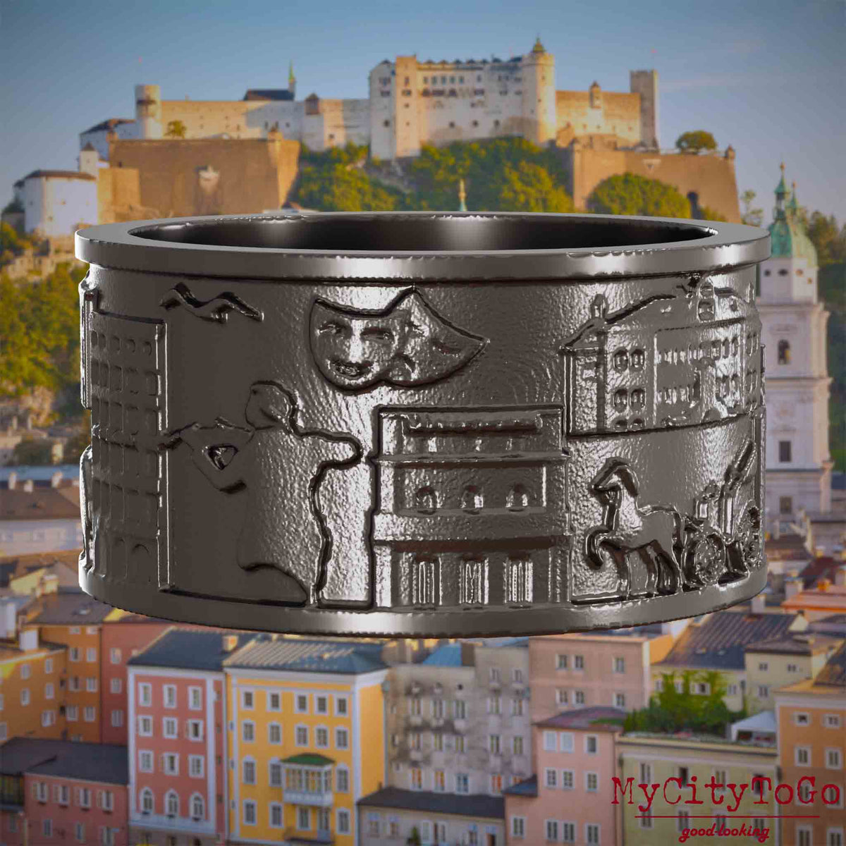 Ring aus Titan mit Reliefs bekannter Sehenswürdigkeiten der Stadt Salzburg. Den Hintergrund bildet eine Ansicht der Stadt Salzburg.