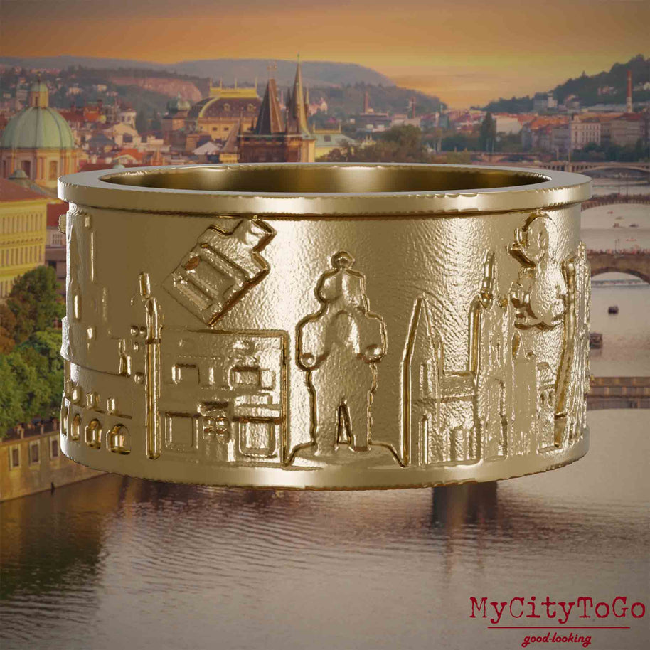 Ring aus vergoldetem Edelstahl mit Reliefs bekannter Sehenswürdigkeiten der Stadt Prag. Den Hintergrund bildet eine Ansicht der Stadt Prag.