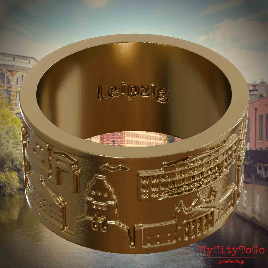Ring aus vergoldetem Edelstahl mit Reliefs bekannter Sehenswürdigkeiten der Stadt Leipzig und einer Gravur des Stadtnamens auf der Innenseite. Den Hintergrund bildet eine Ansicht der Stadt Leipzig.