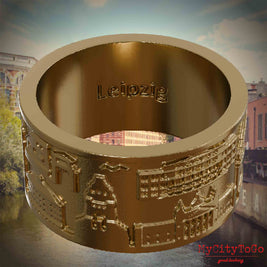 Ring aus vergoldetem Edelstahl mit Reliefs bekannter Sehenswürdigkeiten der Stadt Leipzig und einer Gravur des Stadtnamens auf der Innenseite. Den Hintergrund bildet eine Ansicht der Stadt Leipzig.