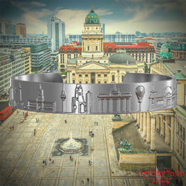 Armreif aus Edelstahl mit Reliefs bekannter Sehenswürdigkeiten der Stadt Berlin. Den Hintergrund bildet eine Ansicht der Stadt Berlin. 