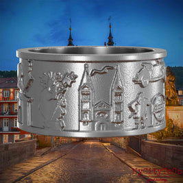 Ring aus Edelstahl mit Reliefs bekannter Sehenswürdigkeiten der Stadt Heidelberg. Den Hintergrund bildet eine Ansicht der Stadt Heidelberg.