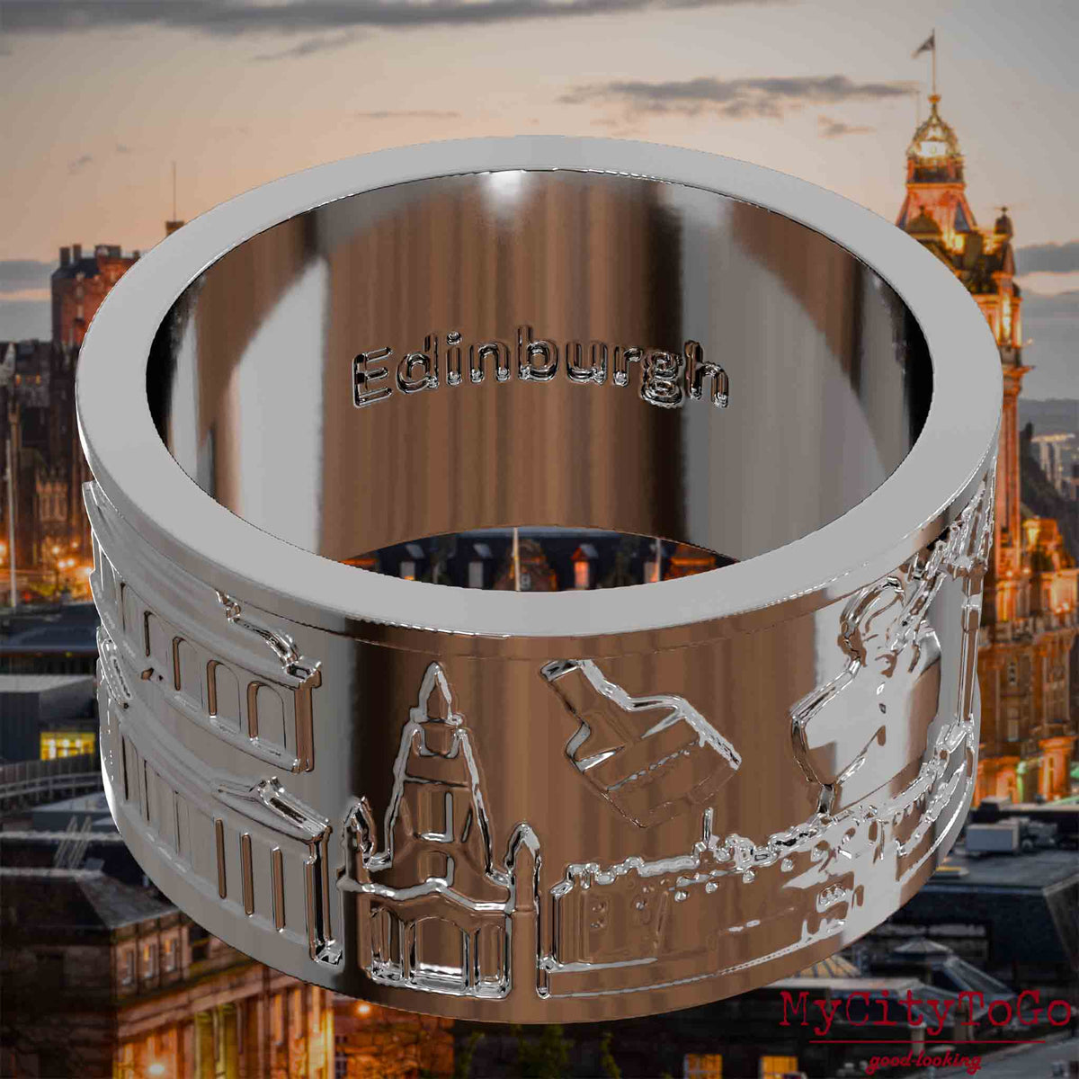 Versilberter Ring mit Reliefs bekannter Sehenswürdigkeiten der Stadt Edinburgh und einer Gravur des Stadtnamens auf der Innenseite. Den Hintergrund bildet eine Ansicht der Stadt Edinburgh.