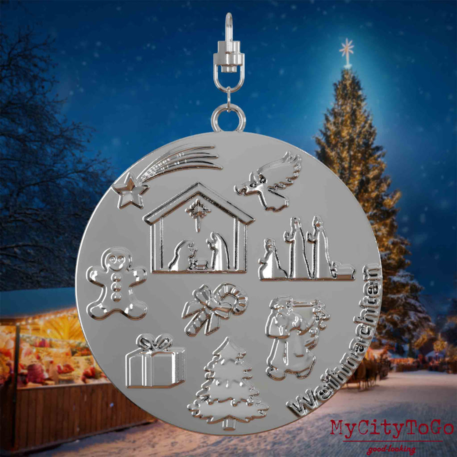 Halskette mit Drehwirbel und Rückseite eines silbernen Schmuckanhängers, auf dem Reliefs bekannter Weihnachst- und Wintermotive abgebildet sind. Den Hintergrund bildet ein naechtliches Weihnachtsmotiv.