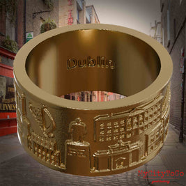 Ring aus vergoldetem Edelstahl mit Reliefs bekannter Sehenswürdigkeiten der Stadt Dublin und einer Gravur des Stadtnamens auf der Innenseite. Den Hintergrund bildet eine Ansicht der Stadt Dublin.