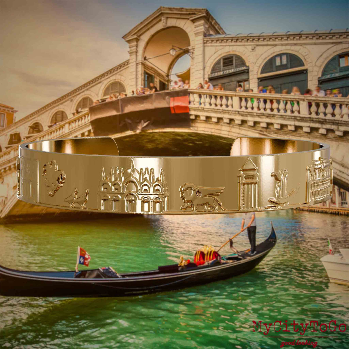 Vergoldeter Armreif mit Reliefs bekannter Sehenswürdigkeiten der Stadt Venedig. Den Hintergrund bildet eine Ansicht der Stadt Venedig.