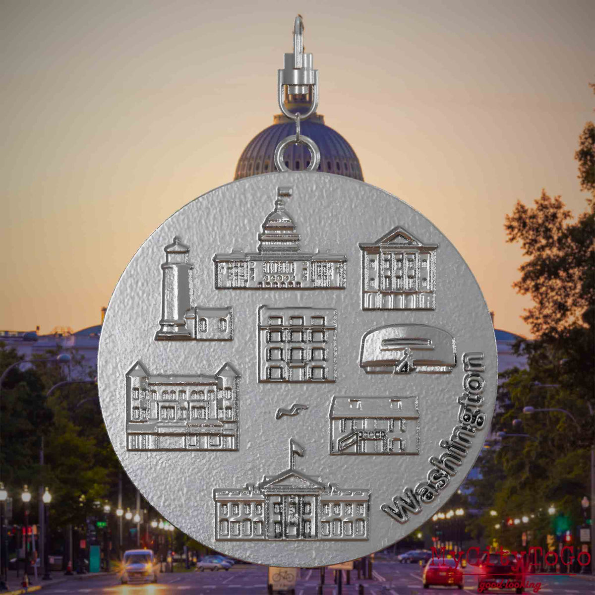 Halskette mit Drehwirbel und Rückseite eines Schmuckanhängers aus Edelstahl, auf dem Reliefs bekannter Sehenswürdigkeiten der Stadt Washington abgebildet sind. Den Hintergrund bildet eine Ansicht der Stadt Washington.
