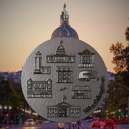 Halskette mit Drehwirbel und Rückseite eines Schmuckanhängers aus Titan, auf dem Reliefs bekannter Sehenswürdigkeiten der Stadt Washington abgebildet sind. Den Hintergrund bildet eine Ansicht der Stadt Washington.
