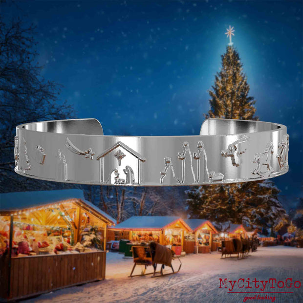 Silberner Armreif mit Reliefs weihnachtlicher Motive. Den Hintergrund bildet ein naechtliches Weihnachtsmotiv.