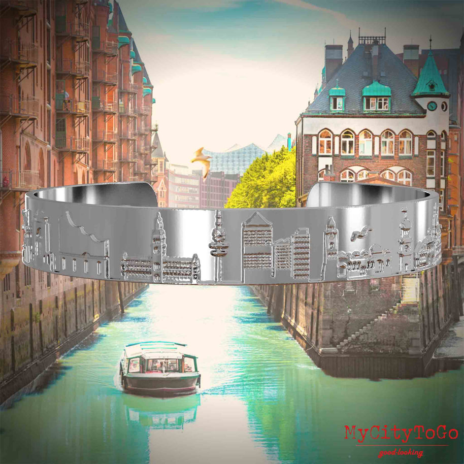 Silver-plated Bangle with reliefs of famous landmarks in the city of Hamburg. The background features a view of the city of Hamburg.
