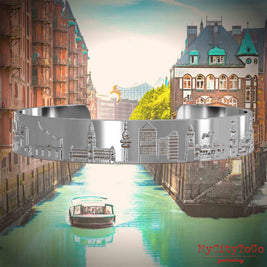 Silver-plated Bangle with reliefs of famous landmarks in the city of Hamburg. The background features a view of the city of Hamburg.