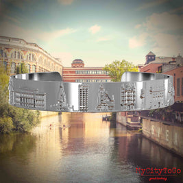 Versilberter Armreif mit Reliefs bekannter Sehenswürdigkeiten der Stad Leipzig. Den Hintergrund bildet eine Ansicht der Stadt Leipzig.