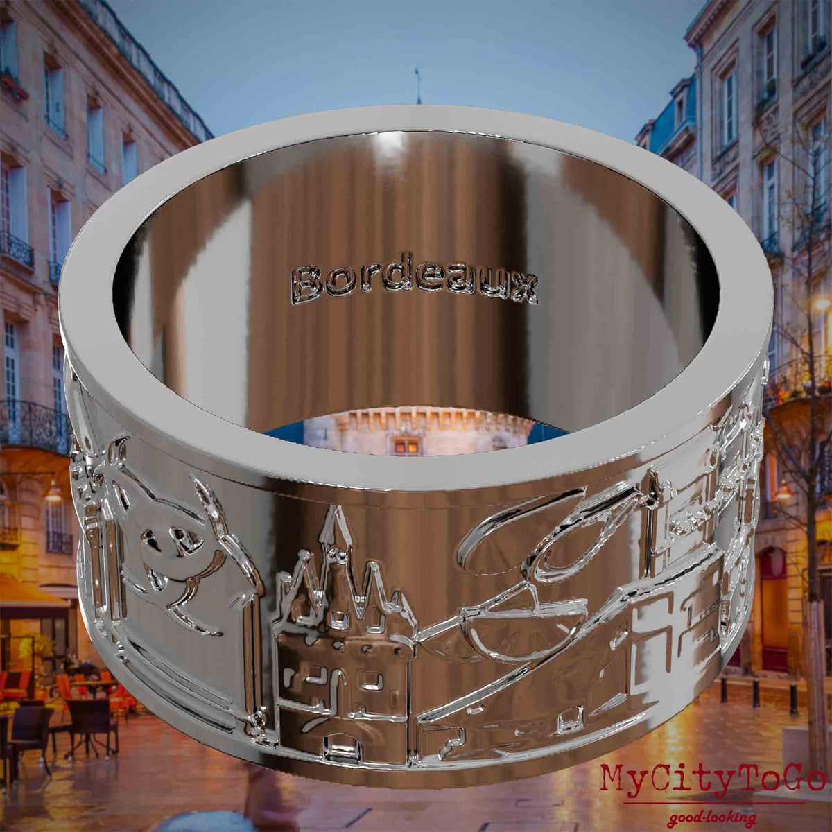 Versilberter Ring mit Reliefs bekannter Sehenswürdigkeiten der Stadt Bordeaux und einer Gravur des Stadtnamens auf der Innenseite. Den Hintergrund bildet eine Ansicht der Stadt Bordeaux.