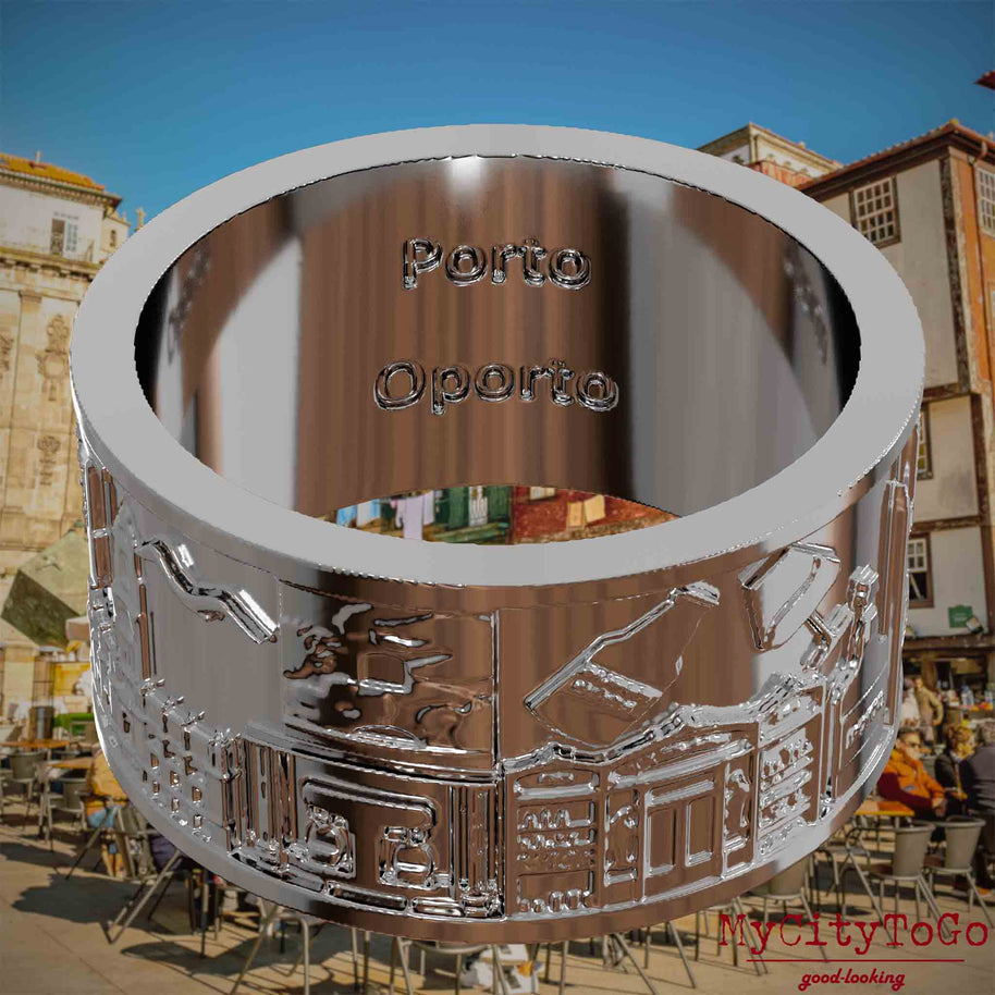 Versilberter Ring mit Reliefs bekannter Sehenswürdigkeiten der Stadt Porto und einer Gravur des Stadtnamens auf der Innenseite. Den Hintergrund bildet eine Ansicht der Stadt Porto.