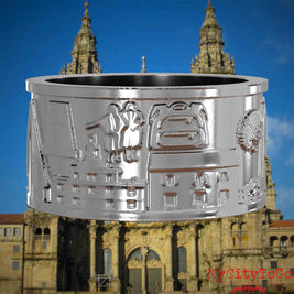Silberner Ring mit Reliefs bekannter Sehenswürdigkeiten und Wahrzeichen auf dem Jakobsweg. Den Hintergrund bildet die Kathedrale von Santiago de Compostela.