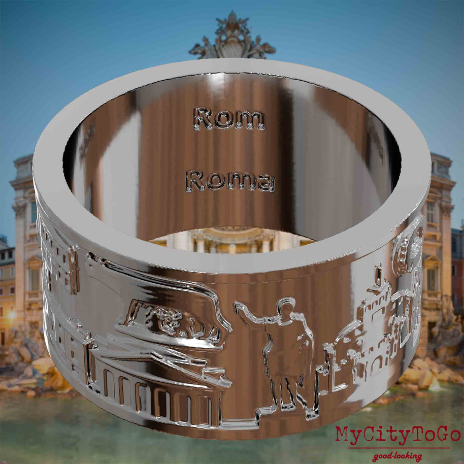 Versilberter Ring mit Reliefs bekannter Sehenswürdigkeiten der Stadt Rom und einer Gravur des Stadtnamens auf der Innenseite. Den Hintergrund bildet eine Ansicht der Stadt Rom.