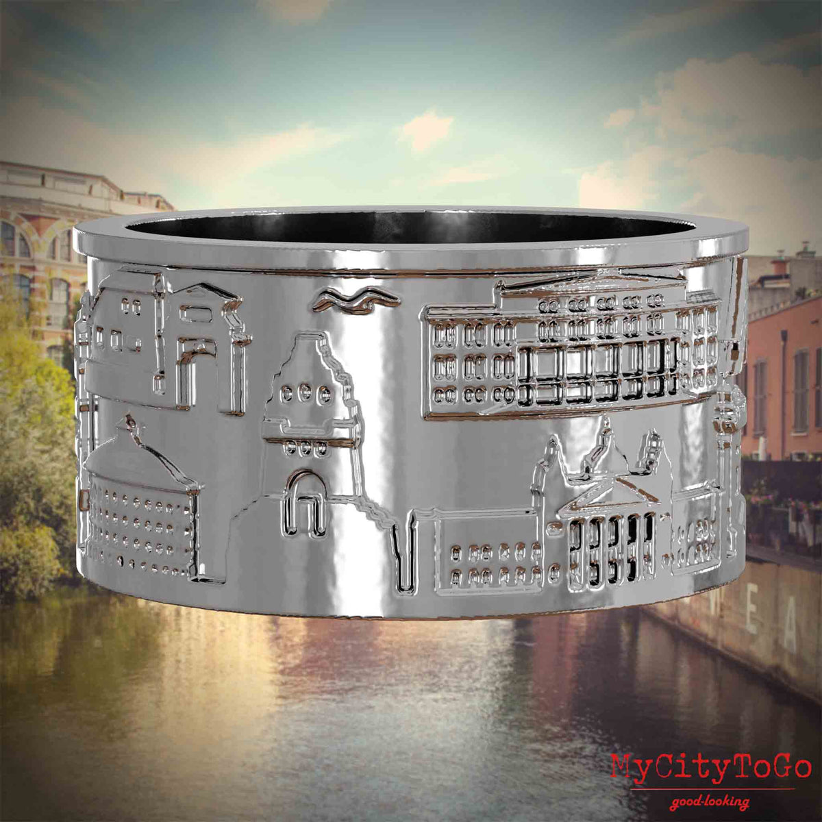 Silberner Ring mit Reliefs bekannter Sehenswürdigkeiten der Stadt Leipzig. Den Hintergrund bildet eine Ansicht der Stadt Leipzig.