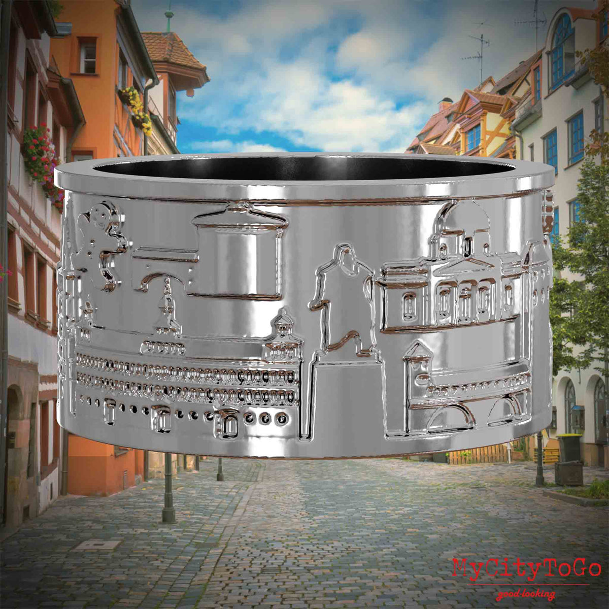 Silberner Ring mit Reliefs bekannter Sehenswürdigkeiten der Stadt Nuernberg. Den Hintergrund bildet eine Ansicht der Stadt  Nuernberg.