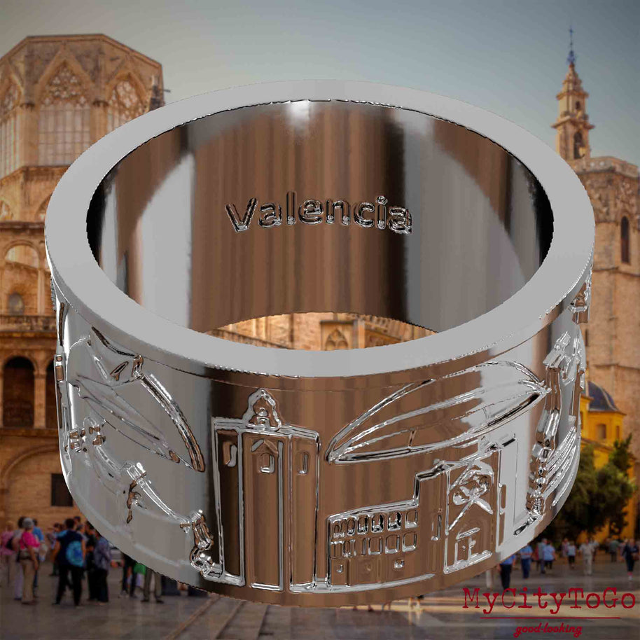 Versilberter Ring mit Reliefs bekannter Sehenswürdigkeiten der Stadt Valencia und einer Gravur des Stadtnamens auf der Innenseite. Den Hintergrund bildet eine Ansicht der Stadt Valencia.