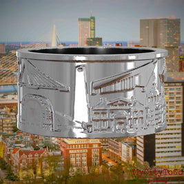 Silberner Ring mit Reliefs bekannter Sehenswürdigkeiten der Stadt Rotterdam. Den Hintergrund bildet eine Ansicht der Stadt Rotterdam.