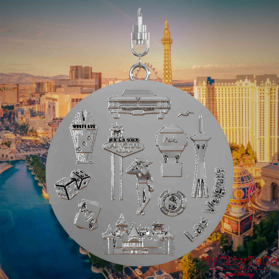 Necklace with swivel clasp and the back of a silver jewelry pendant featuring reliefs of well-known Las Vegas landmarks. The background shows a view of the city of Las Vegas.