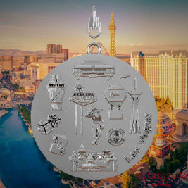 Necklace with swivel clasp and the back of a silver jewelry pendant featuring reliefs of well-known Las Vegas landmarks. The background shows a view of the city of Las Vegas.