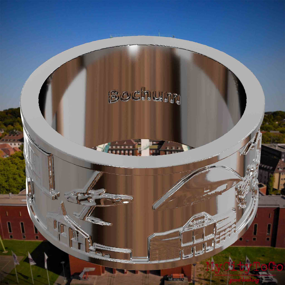 Versilberter Ring mit Reliefs bekannter Sehenswürdigkeiten der Stadt Bochum und einer Gravur des Stadtnamens auf der Innenseite. Den Hintergrund bildet eine Ansicht der Stadt Bochum.