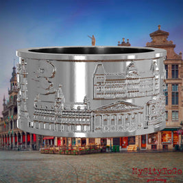 Silberner Ring mit Reliefs bekannter Sehenswürdigkeiten der Stadt Bruessel. Den Hintergrund bildet eine Ansicht der Stadt Bruessel.