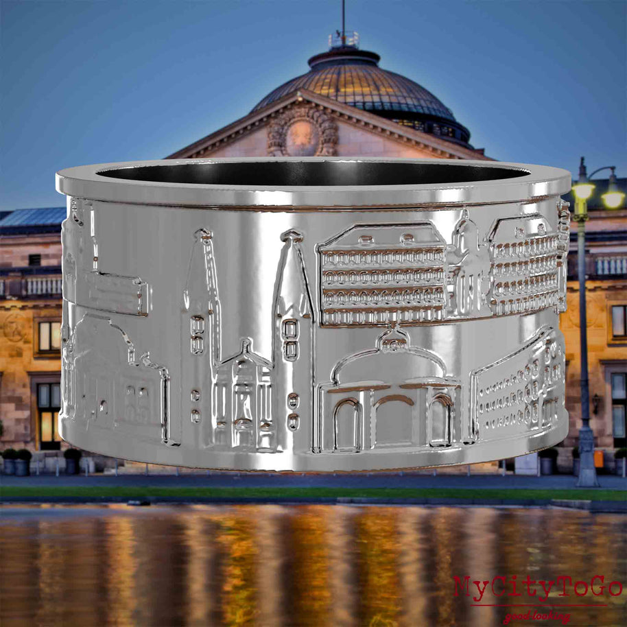 Silberner Ring mit Reliefs bekannter Sehenswürdigkeiten der Stadt Wiesbaden. . Den Hintergrund bildet eine Ansicht der Stadt Wiesbaden.