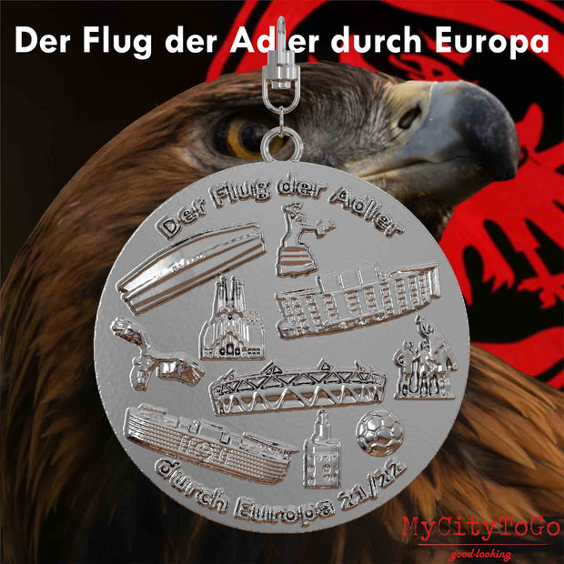 Silberner Schmuckanhänger mit Reliefs von Stadien und Wahrzeichen der Spielorte der Finalrunde der Frankfurter Europa-League-Saison 2021/22 auf der Vorderseite
