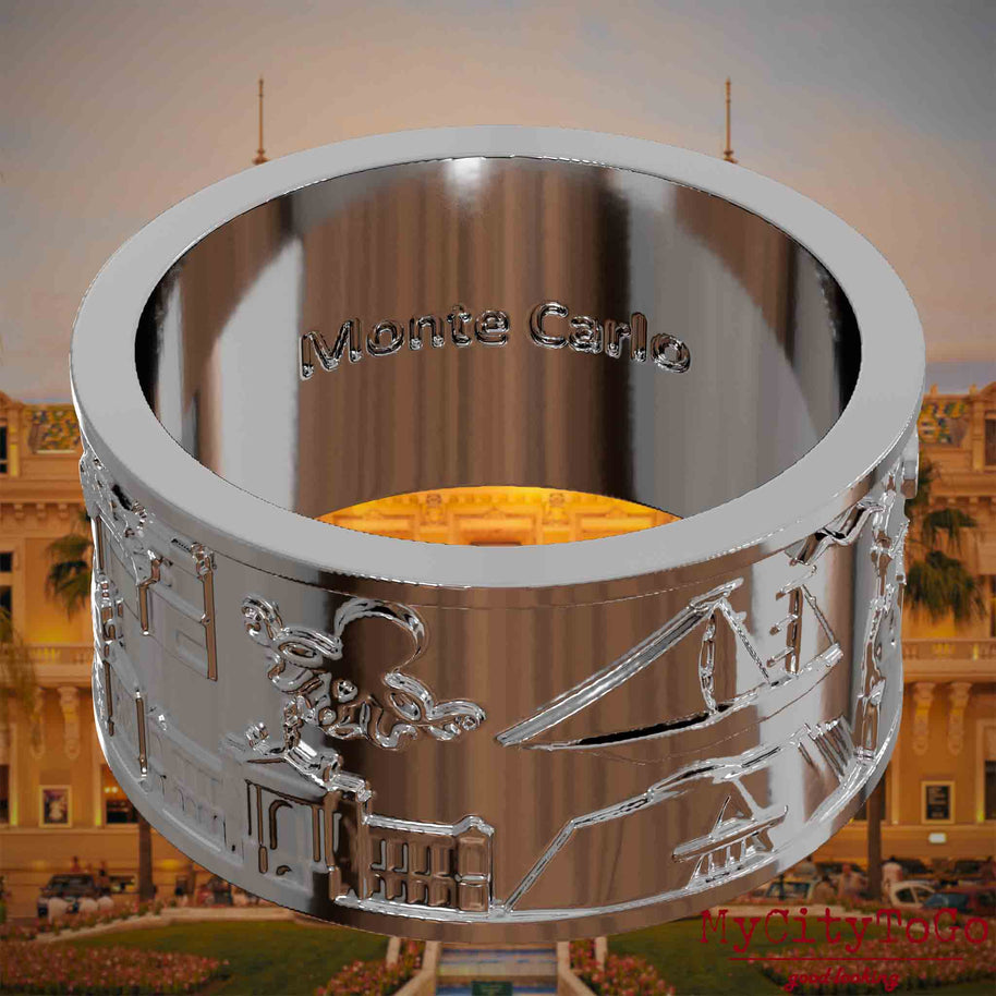 Versilberter Ring mit Reliefs bekannter Sehenswürdigkeiten der Stadt Monte Carlo und einer Gravur des Stadtnamens auf der Innenseite. Den Hintergrund bildet eine Ansicht der Stadt Monte Carlo.