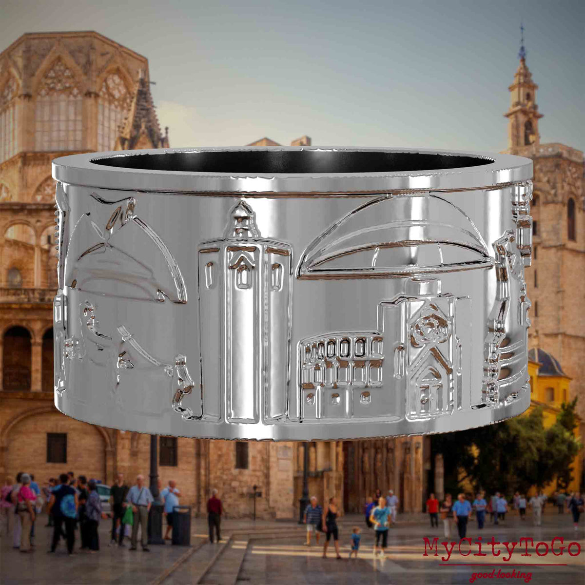 Silberner Ring mit Reliefs bekannter Sehenswürdigkeiten der Stadt Valencia. Den Hintergrund bildet eine Ansicht der Stadt Valencia.