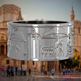 Silberner Ring mit Reliefs bekannter Sehenswürdigkeiten der Stadt Valencia. Den Hintergrund bildet eine Ansicht der Stadt Valencia.