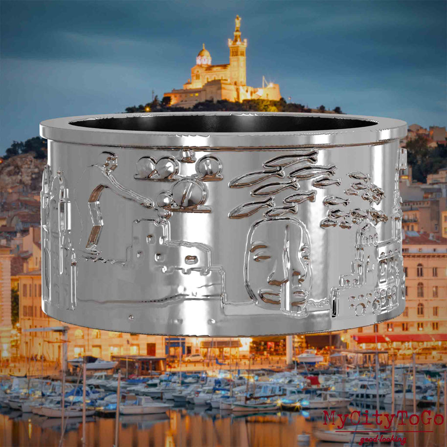 Silberner Ring mit Reliefs bekannter Sehenswürdigkeiten der Stadt Marseille. Den Hintergrund bildet eine Ansicht der Stadt Marseille.