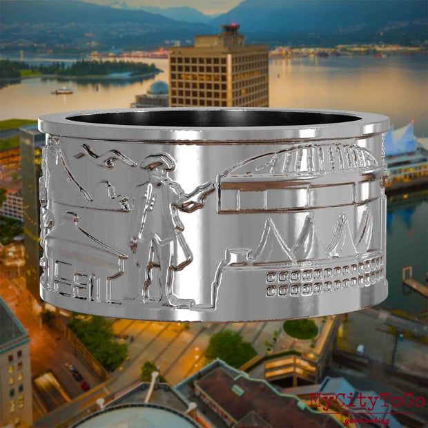 Silberner Ring mit Reliefs bekannter Sehenswürdigkeiten der Stadt Vancouver. Den Hintergrund bildet eine Ansicht der Stadt Vancouver.