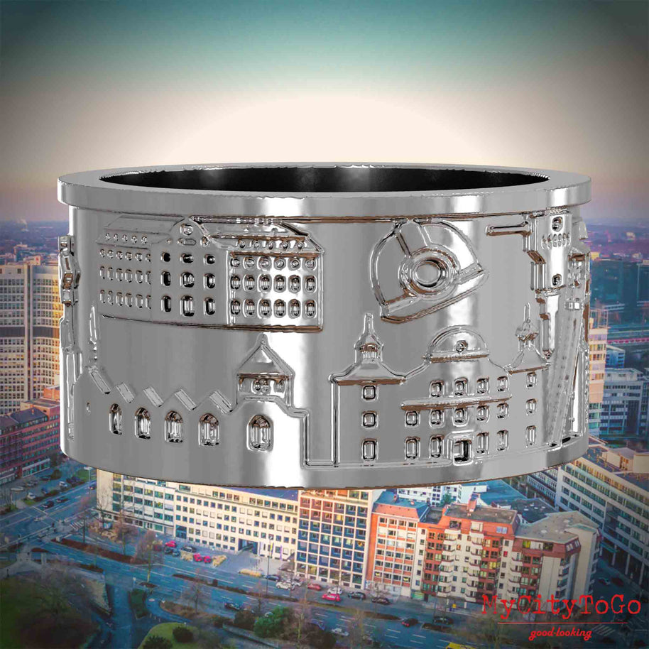 Silberner Ring mit Reliefs bekannter Sehenswürdigkeiten der Stadt Essen. Den Hintergrund bildet eine Ansicht der Stadt Essen.