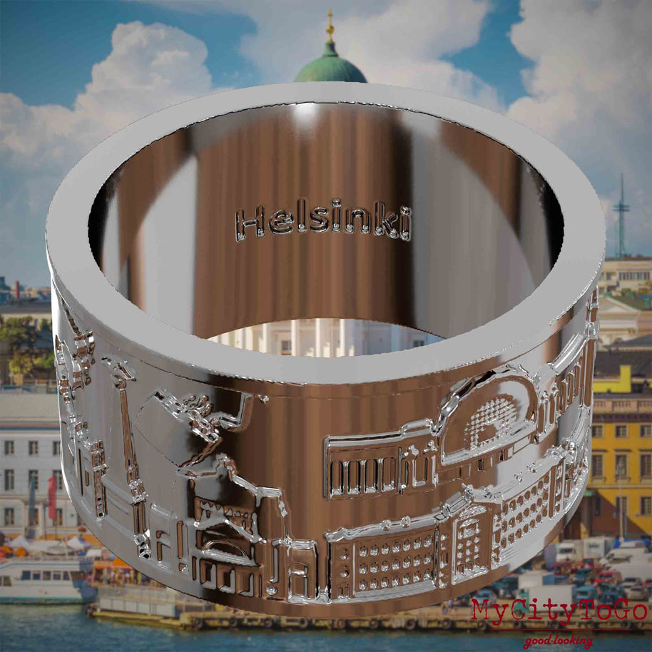 Versilberter Ring mit Reliefs bekannter Sehenswürdigkeiten der Stadt Helsinki und einer Gravur des Stadtnamens auf der Innenseite. Den Hintergrund bildet eine Ansicht der Stadt Helsinki.