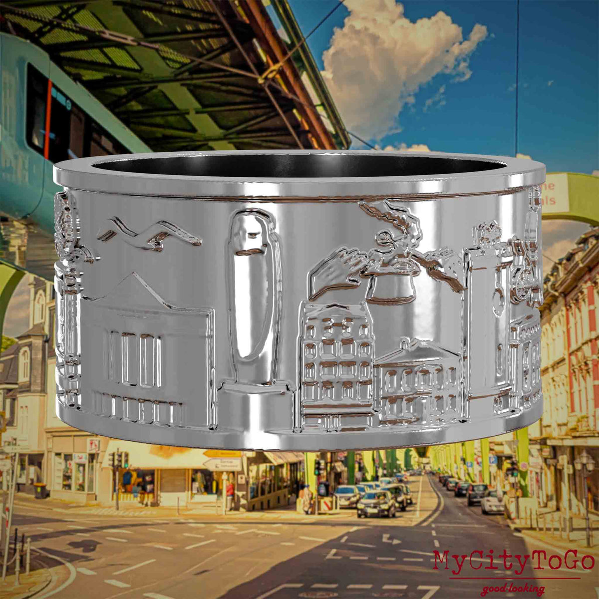 Silberner Ring mit Reliefs bekannter Sehenswürdigkeiten der Stadt Wuppertal. Den Hintergrund bildet eine Ansicht  der Stadt Wuppertal.