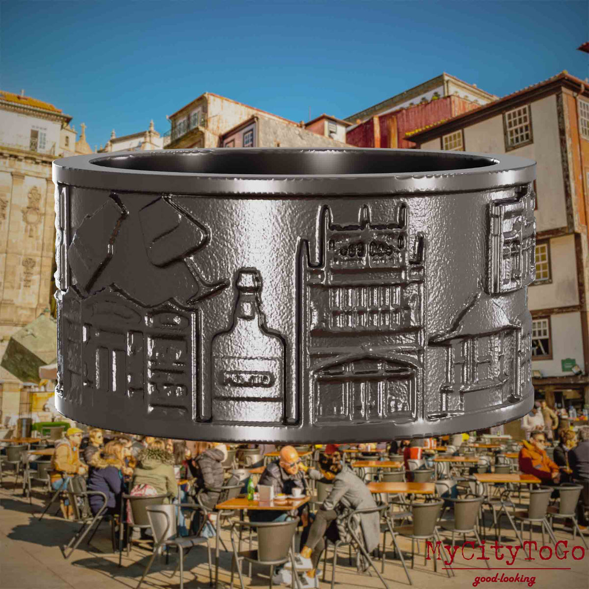 Ring aus Titan mit Reliefs bekannter Sehenswürdigkeiten der Stadt Porto. Den Hintergrund bildet eine Ansicht der Stadt Porto.