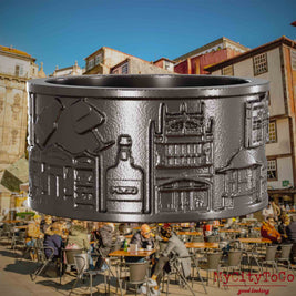 Ring aus Titan mit Reliefs bekannter Sehenswürdigkeiten der Stadt Porto. Den Hintergrund bildet eine Ansicht der Stadt Porto.