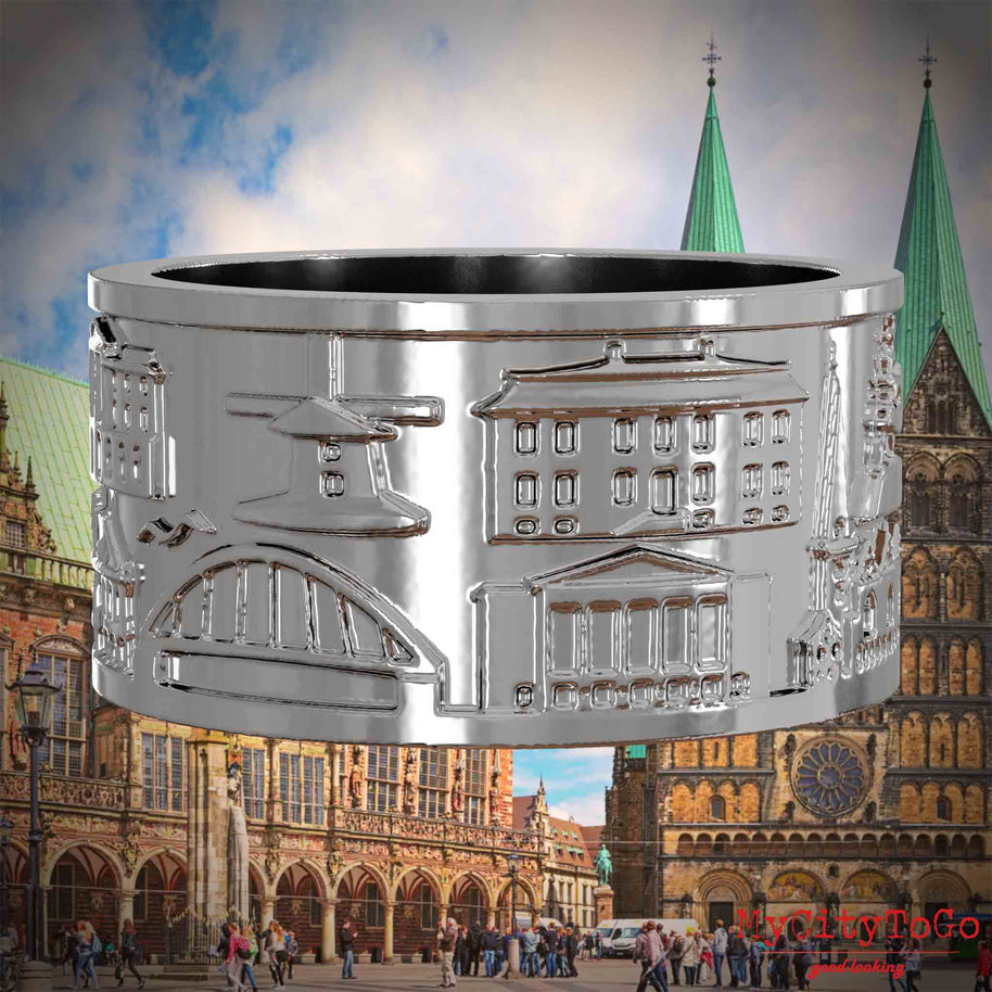 Silberner Ring mit Reliefs bekannter Sehenswürdigkeiten der Stadt Bremen. Den Hintergrund bildet eine Ansicht der Stadt Bremen.