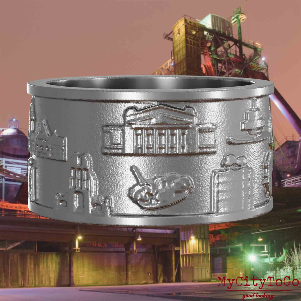 Ring aus Edelstahl mit Reliefs bekannter Sehenswürdigkeiten der Stadt Duisburg. Den Hintergrund bildet eine Ansicht der Stadt Duisburg.