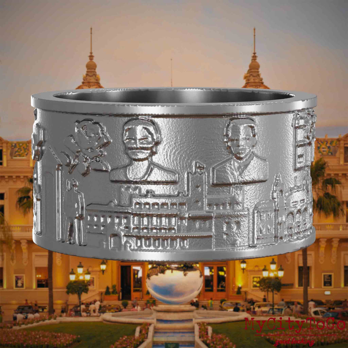 Ring aus Edelstahl mit Reliefs bekannter Sehenswürdigkeiten der Stadt Monte Carlo. Den Hintergrund bildet eine Ansicht der Stadt Monte Carlo.