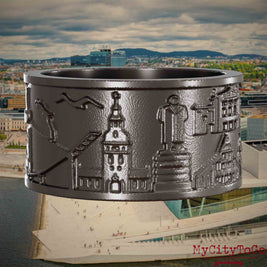 Ring aus Titan mit Reliefs bekannter Sehenswürdigkeiten der Stadt Oslo. Den Hintergrund bildet eine Ansicht der Stadt Oslo.