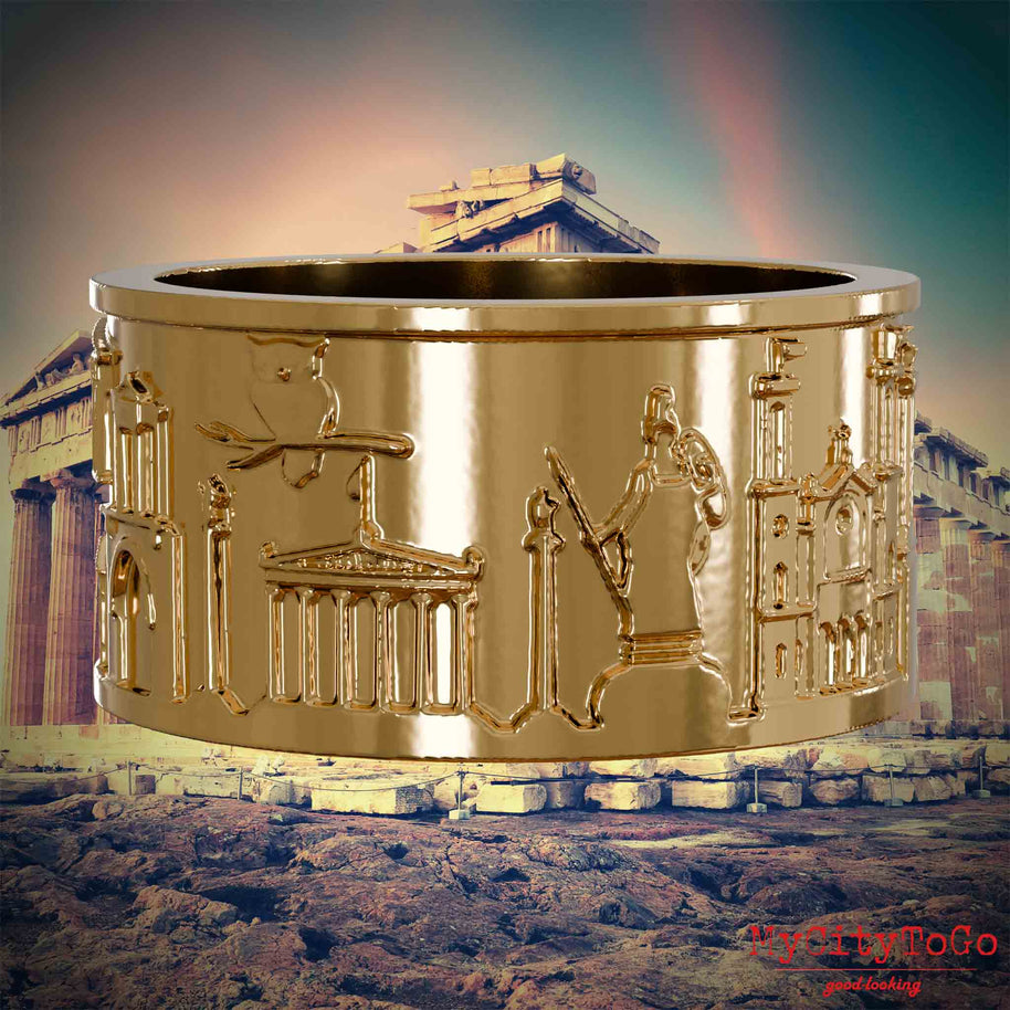 Vergoldeter Ring mit Reliefs bekannter Sehenswürdigkeiten der Stadt Athen. Den Hintergrund bildet eine Ansicht der Stadt Athen.