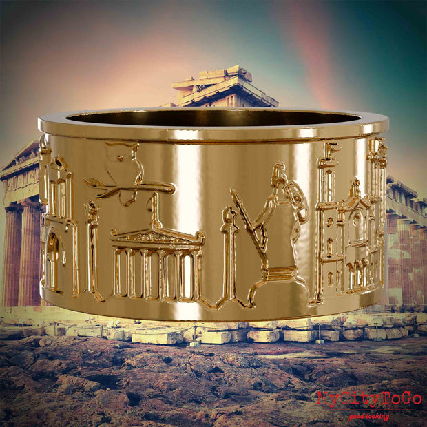 Vergoldeter Ring mit Reliefs bekannter Sehenswürdigkeiten der Stadt Athen. Den Hintergrund bildet eine Ansicht der Stadt Athen.