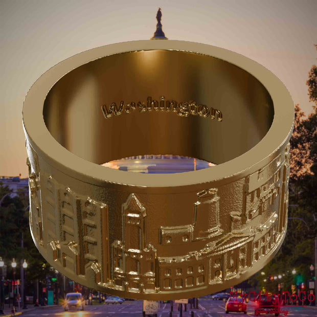 Ring aus vergoldetem Edelstahl mit Reliefs bekannter Sehenswürdigkeiten der Stadt Washington und einer Gravur des Stadtnamens auf der Innenseite. Den Hintergrund bildet eine Ansicht der Stadt Washington.