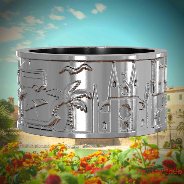 Silberner Ring mit Reliefs bekannter Sehenswürdigkeiten der Stadt Palma de Mallorca. Den Hintergrund bildet eine Ansicht der Stadt Palma de Mallorca.