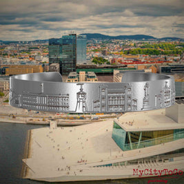 Armreif aus Edelstahl mit Reliefs bekannter Sehenswürdigkeiten der Stadt Oslo. Den Hintergrund bildet eine Ansicht der Stadt Oslo.